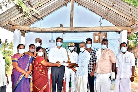 Collector M Govinda Rao handing over the money to Ravichandran in Thanjavur