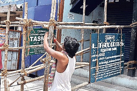 Workers setting up barricades in front of Tasmac outlets in the city