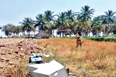 Parts of the lifted ATM scattered by the thieves on empty land in Erode on Monday