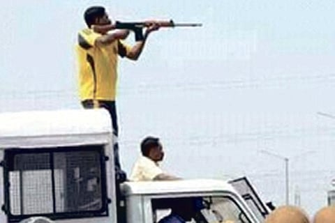 The cop firing at the crowd from atop a police van (file pic)