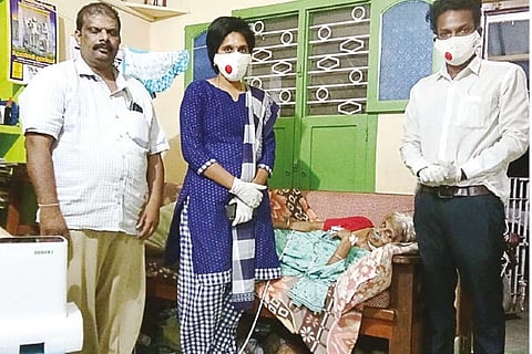 Dr Ravi Sankar using the oxygen concentrator machine to help a patient restore oxygen level