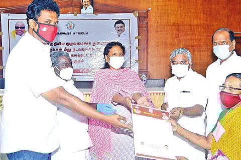 Tiruvarur Collector V Santha, MLAs Poondi K Kalaivanan and TRB Rajaa presenting aid to a beneficiary