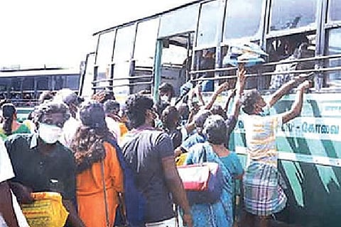 Passengers scramble to board a bus in Tirupur on Sunday