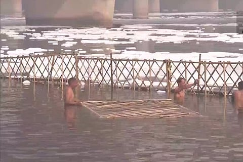 Barricades being placed in the Yamuna to stop toxic foam