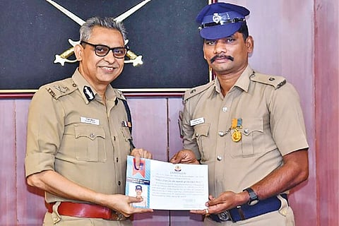 Saravanakumar (right) accepting reward from CoP Shankar Jiwal