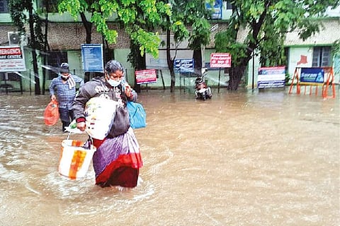 People walk in knee-deep water in Tambaram GH
