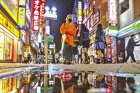 People walk along streets in Shibuya as Japan fully came of COVID-19 emergency in more than 6 months