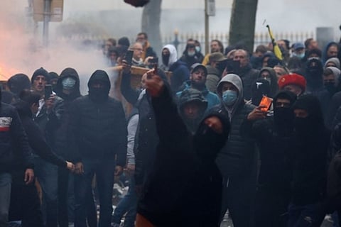 A protester throws stones towards riot police in Brussels (Image credit: AFP)