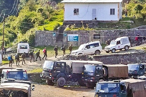 Security forces stand guard at the encounter site in Surankote area of Poonch on Monday