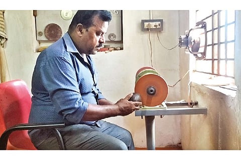 R Kumaraguru working on a machine made by him to polish a coconut shell in Thanjavur