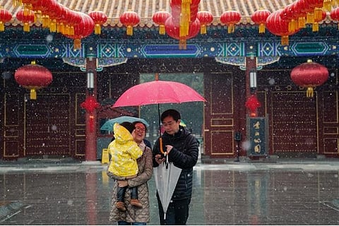 A couple walking with their kid in Beijing streets