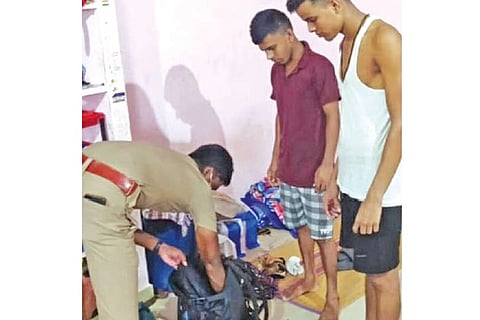 A policeman seen searching the belongings of some guest workers