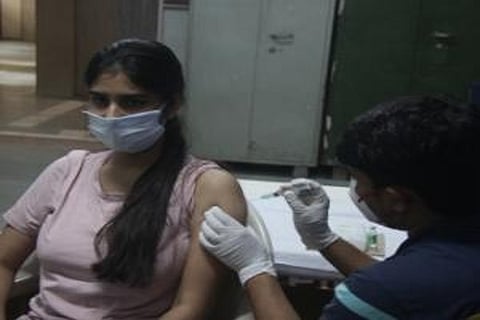 A woman getting covid jab from a healthcare worker