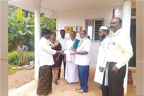 A Kettakadu hamlet resident receives power card for first time from EB officials in Yelagiri