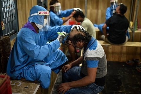 Temple barbers wearing protective suits tonsure the heads of devotees inside Tonsuring Hall | PTI