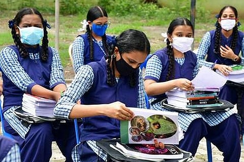Students with textbooks. File photo