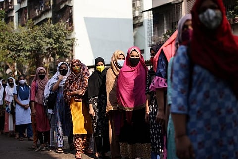 Students stand in line as they wait to enter a school (Credit: Reuters)