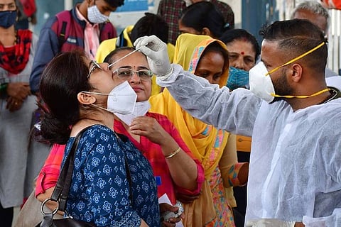 A healthcare worker collects covid sample from a women (File Photo)