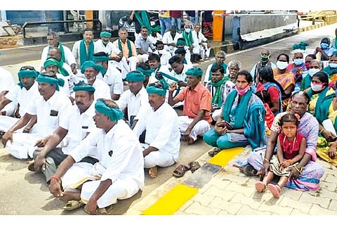 Farmers blocking the lanes at the toll plaza in Thuvakudi, Tiruchy, on Thursday