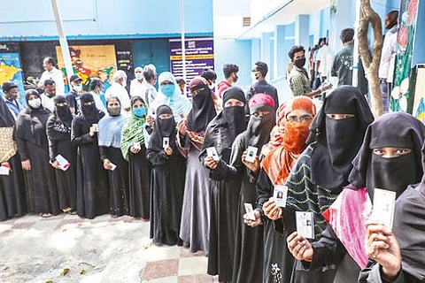 Women stand in queue to cast their votes, in Krishnagiri, on Saturday