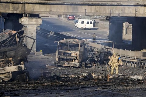 A Ukrainian soldier walks past debris of a burning military truck in Kyiv/AP