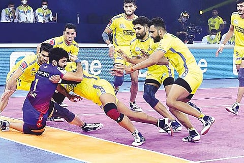 Tamil Thalaivas defence tries to pin down Dabang Delhi raider Vijay.