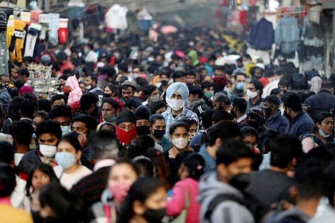 People shop at a crowded market, in New Delhi (Credit: Reuters)