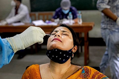 An health worker takes a nasal swab sample of a teacher to test for Covid-19 (Credit: AP)