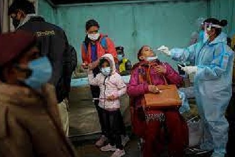 A healthcare worker collects test swab sample from a woman (Credit: Reuters)