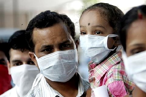 People wearing masks wait in a queue