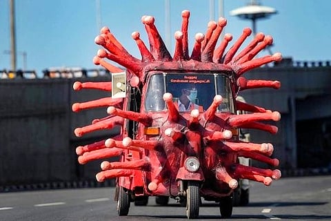 A man drives an auto-rickshaw depicting the coronavirus to create awareness (Credit: AFP)