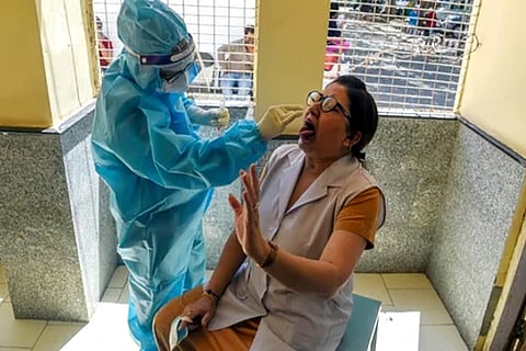 A Medic in PPE takes swab samples from a health worker for RT-PCR (Credit: ANI)