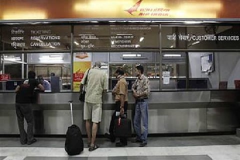 Stranded passengers stand outside the Air India counter at the domestic airport (Credit: Reuters)