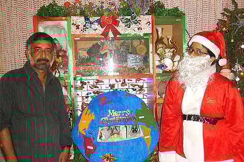 C.A. John and Santa Claus next to the crib designed by him, at his residence