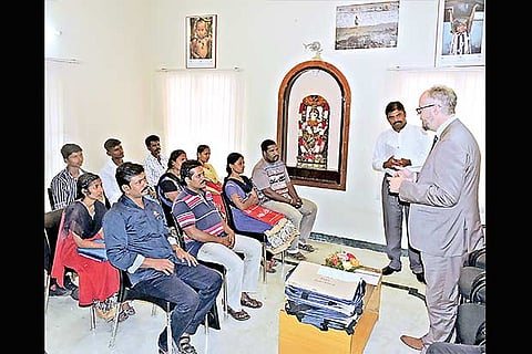 German Consul General Achim Fabig handing out air tickets and documentation kits to the refugees