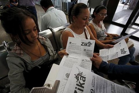 South American women reading a Zika pamphlet