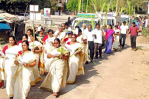 Christians take out a procession with crosses fashioned out of palm leaves to mark Palm Sunday