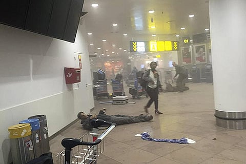 An injured man lies at the scene of explosions at Zaventem airport near Brussels, Belgium