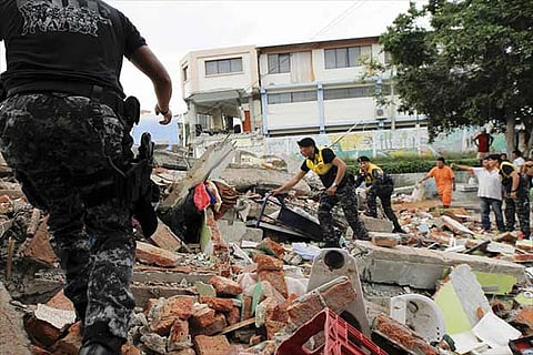 Police and the public search the debris for survivors of the quake