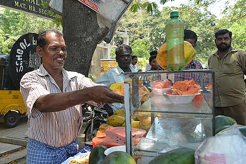 Dhanapal M serves a plate of fresh papayas to a customer (Photo: Justin George)