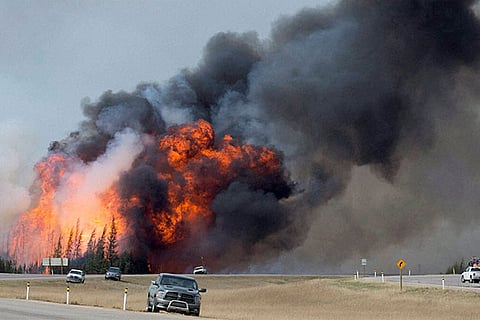 A wildfire burns south of Fort McMurray, Alberta, near Highway 63 on Saturday