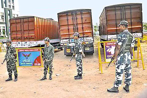 Security personnel stand guard near three container lorries that were found with Rs 570 crore