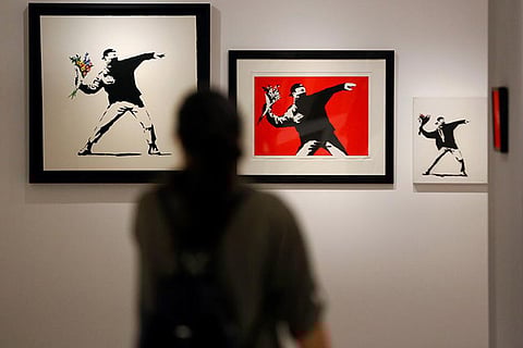 A visitor gazes at one of Bransky?s famous works, of a man throwing a bouquet, at the museum