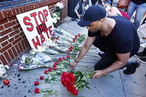 A man lays down 50 roses to honour each victim of the Orlando gay night club shooting