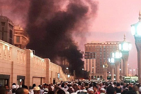Worshippers gather after a blast in Medina on Monday