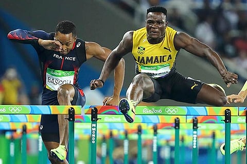 Omar McLeod of Jamaica (right) enroute to 110 m hurdles gold
