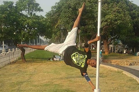A gymnast performs a stunt at a city park