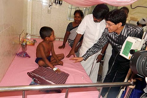 Health Minister C Vijayabaskar and Secretary of health department interact with a child