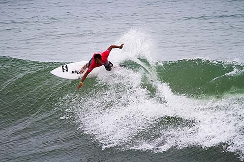A surfer rides the tide at Covelong