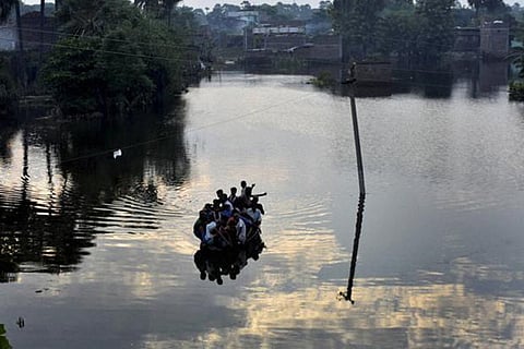 People on boat move during flooded river in Didarganj area in Patna